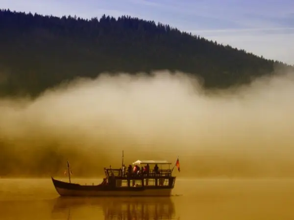 Лодка плывет по реке в утреннем тумане