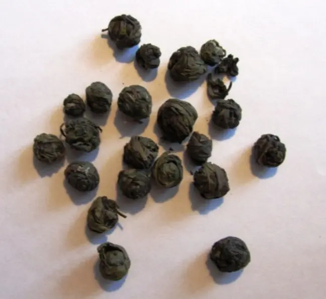 Чаинки зеленного чая скрученые в  маленькие шарики похожие на жемчужины